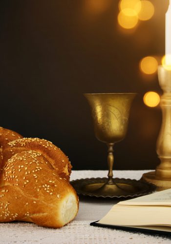 shabbat image. challah bread, shabbat wine and candles on the table.
